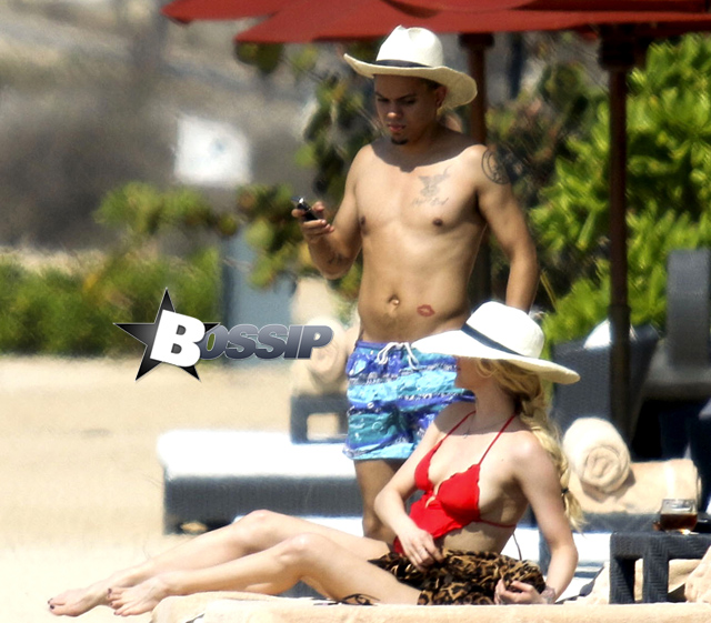 Newlyweds Ashlee Simpson and Evan Ross take in the beauty of Bali and hit the beach to catch some sun. Ashlee wore a one piece red bathing suit and large sun hat to match husband Evan Ross. At one point, Evan took some time to take a cell phone photo of Ashlee sunbathing with the beautiful backdrop of the ocean behind her as a backdrop.
