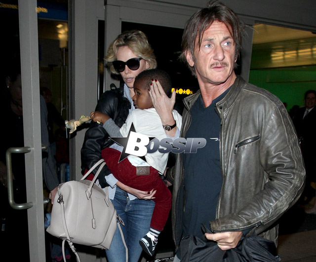 Charlize Theron and Sean Penn arrive at LAX airport with Charlize's son Jackson Theron, where Charlize covers her son face as they head to the car.