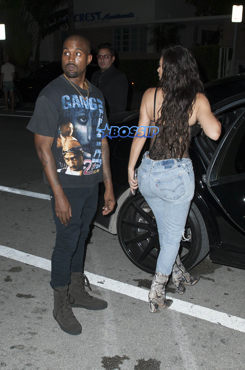 Kim Kardashian Kanye West Prime One Twelve dinner in Miami SplashNews black lacy corset top wardrobe malfunction tupac gang related tee shirt