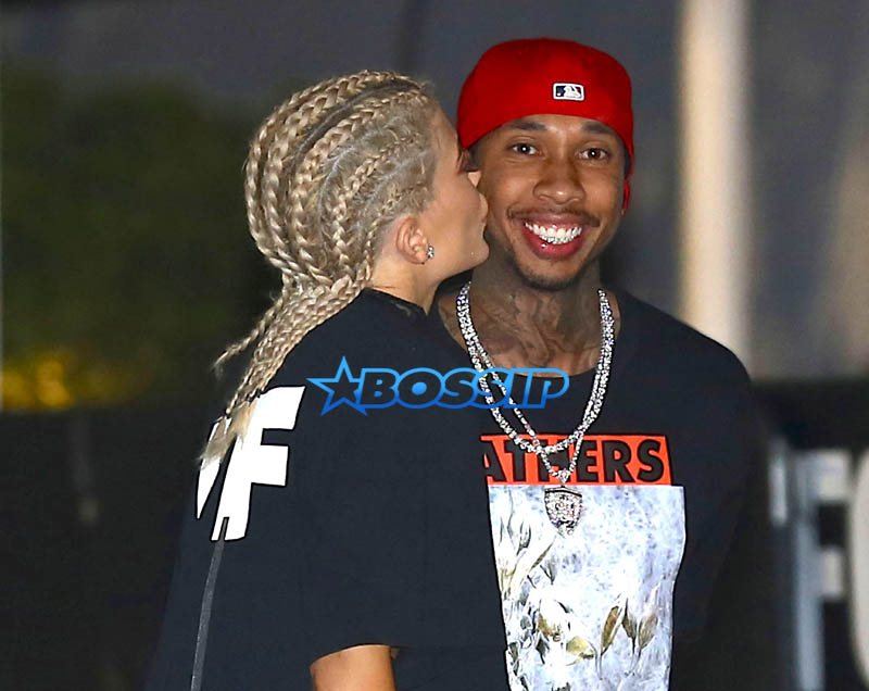 AKM-GSI Kylie Jenner boyfriend Tyga kiss Kanye West's Saint Pablo LA Tour tThe Forum. T Jordyn Woods security. dressed oversized black shirt, cherry red shoes cornrows, braids.