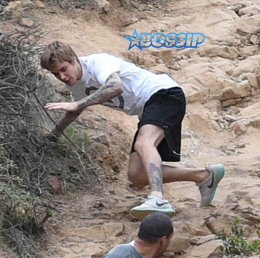 Justin Bieber run rainy windy day falls hike generosity water WENN