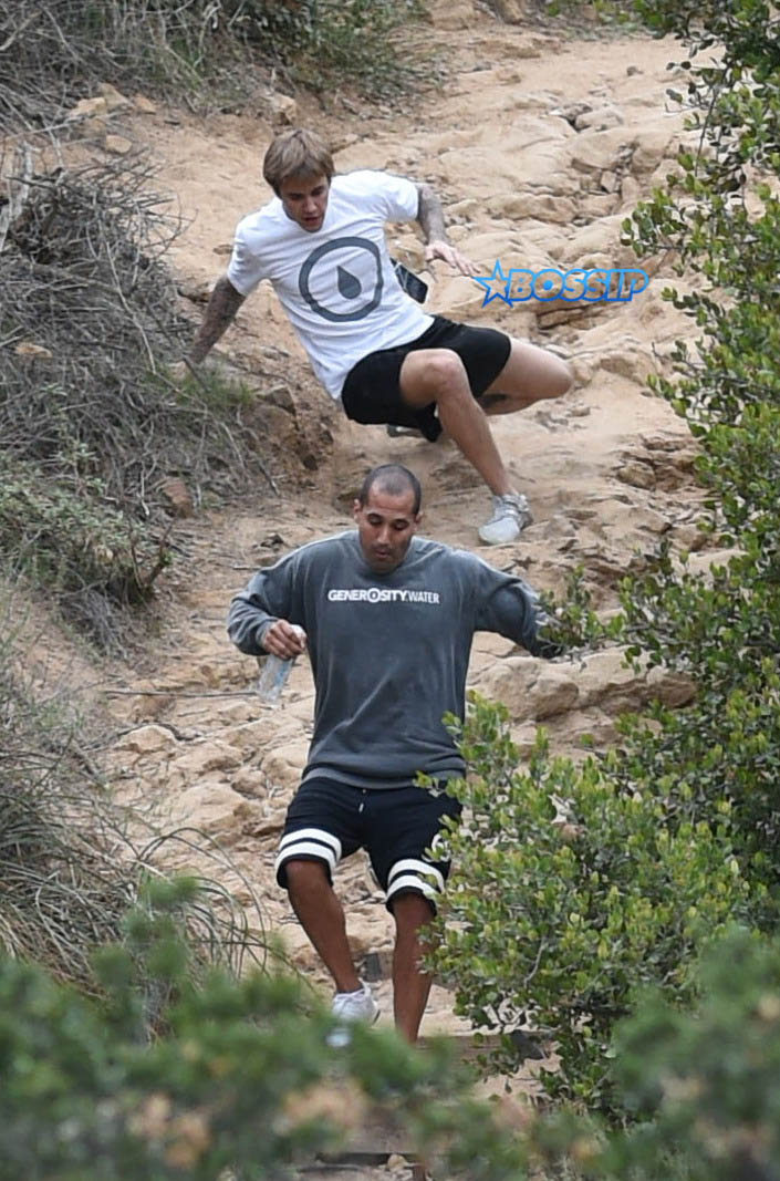Justin Bieber run rainy windy day falls hike generosity water WENN