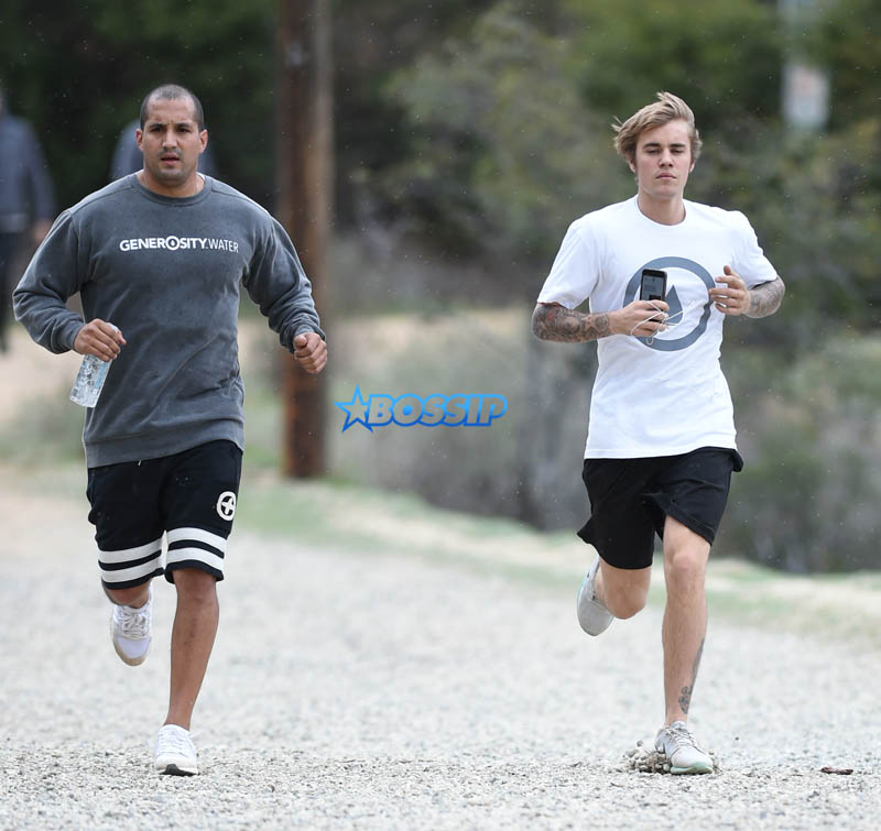 Justin Bieber run rainy windy day falls hike generosity water WENN