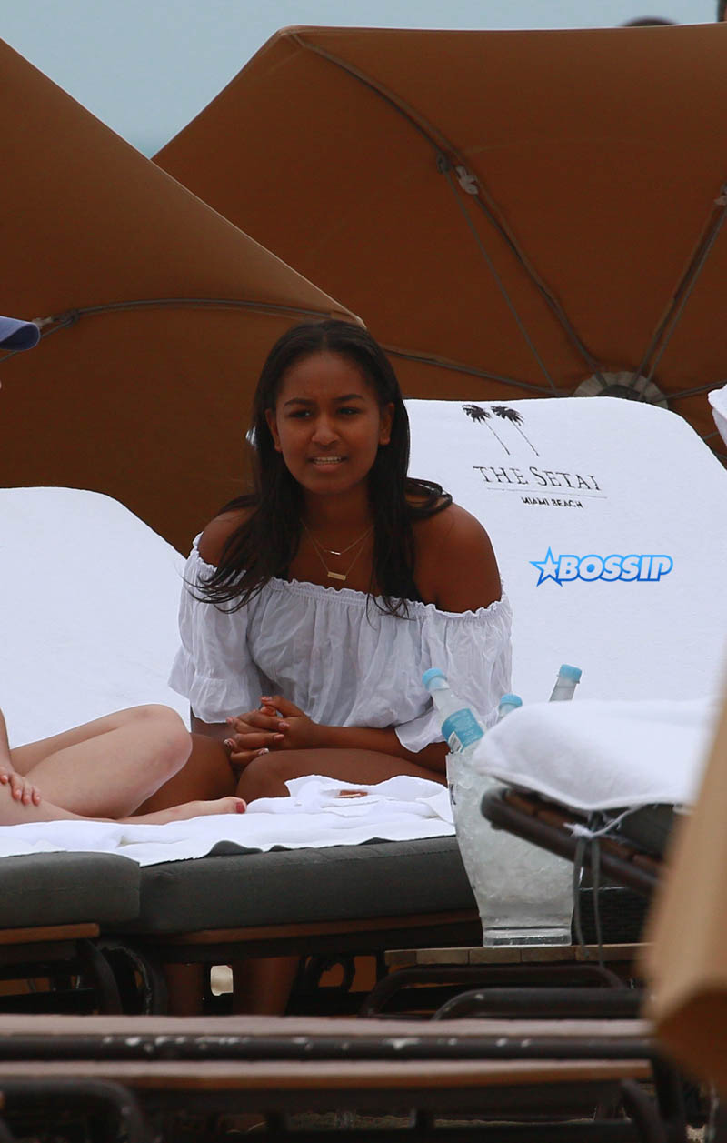 Sasha Obama beach in Miami President Obama's 15-year-old daughter Saturday afternoon. surrounded by secret service agents in plain clothes and hotel security. black bikini top print shorts white off the shoulder top SplashNews