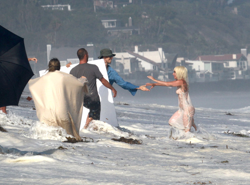 Lady Gaga topless wearing a bikini and thong lingerie for a photoshoot on the beach in Malibu California. The wet and wild photographers and crew got soaked by the big waves.