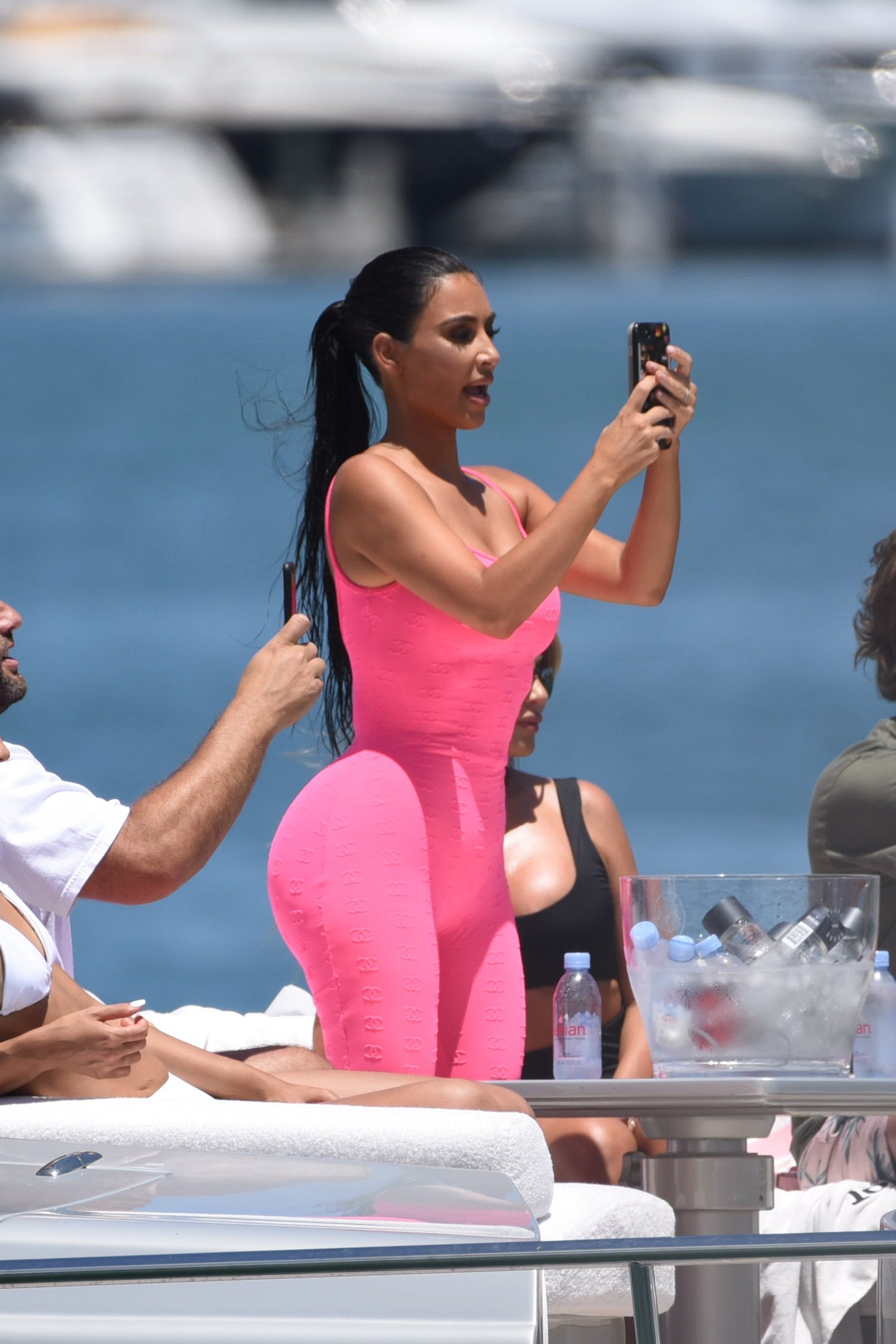 Kim Kardashian curves vintage hot pink Chanel onesie Miami boat trip. cute kids North and Saint, OG crew Jonathan Cheban and Larsa Pippen. Dave Grutman's 'Groot boat Larsa's  daughter Sophia Pippen, ABC's Dancing With The Stars: Juniors.
