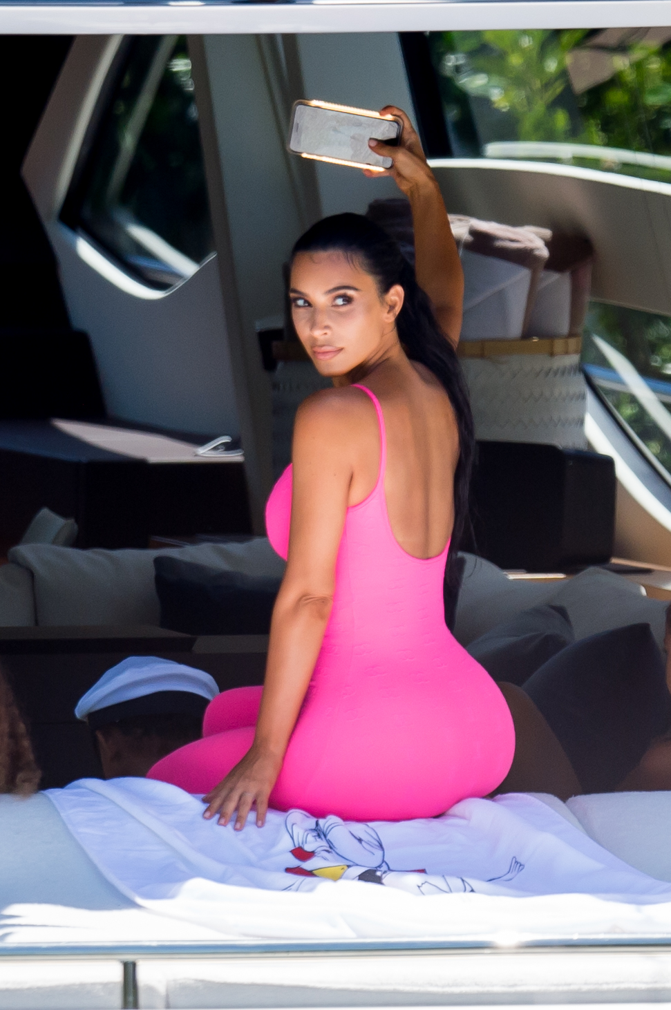 Kim Kardashian curves vintage hot pink Chanel onesie Miami boat trip. cute kids North and Saint, OG crew Jonathan Cheban and Larsa Pippen. Dave Grutman's 'Groot boat Larsa's  daughter Sophia Pippen, ABC's Dancing With The Stars: Juniors.