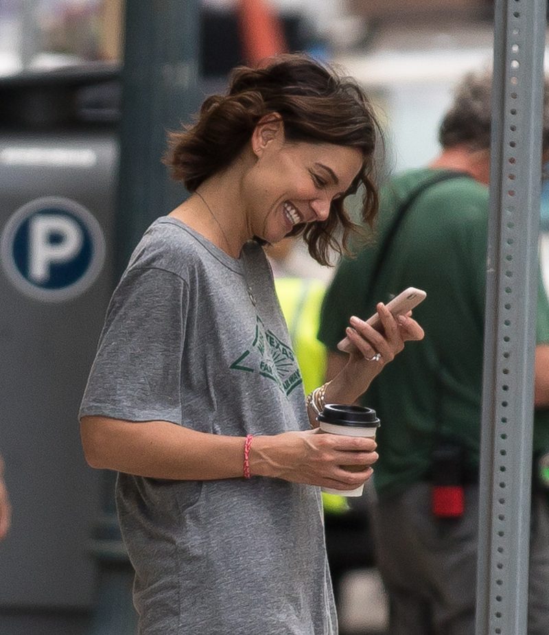 Katie Holmes looks happy while taking a break from filming in New Orleans on Wednesday. Katie was on the set of her new movie The Secret and was spotted wearing a diamond ring on her little finger as she chatted on FaceTime on her phone. Her boyfriend Jamie Foxx is also in town shooting a different movie.