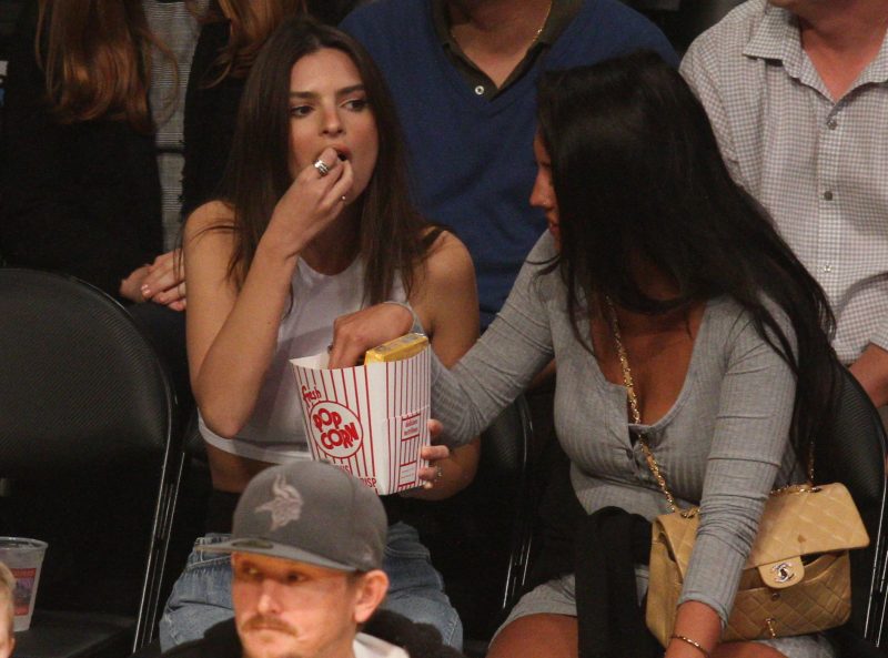 Model Emily Ratajkowski manages to get a dad who was sitting in front of her checking out her buns as she shows of her spectacular assets as she poses courtside while attending the Los Angeles Lakers Vs The Minnesota Timberwolves game at The Staples Center in Los Angeles, Ca