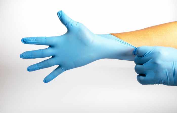 Human holding Variation of Latex Glove, Rubber glove manufacturing, human hand is wearing a medical glove, glove, isolated