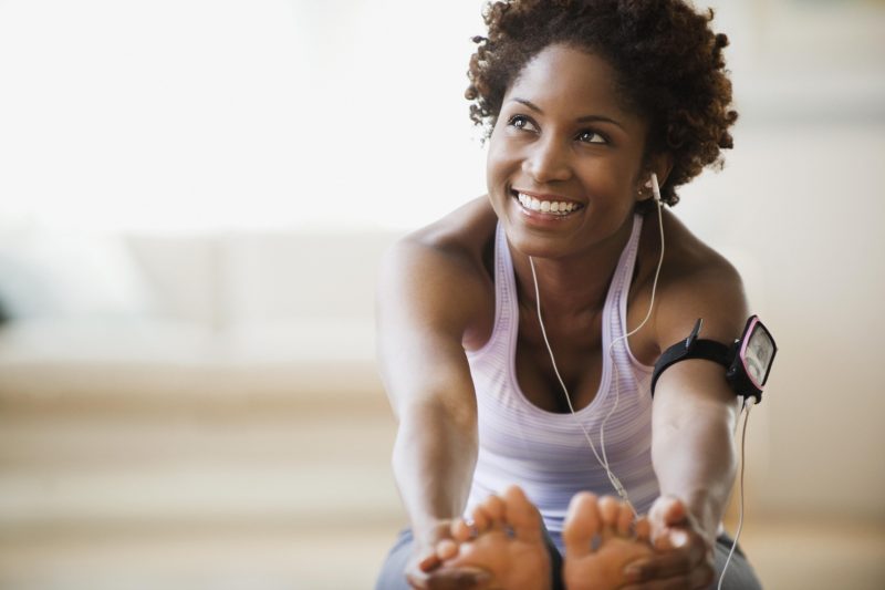 Black woman stretching and listening to mp3 player