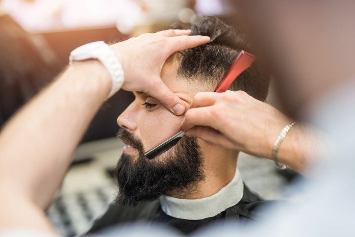 Young man getting his beard shaved.