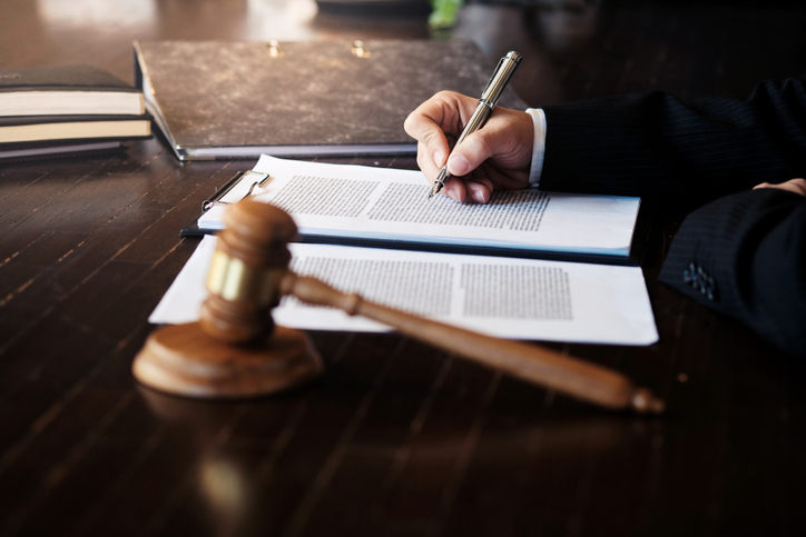 Midsection Of Judge Writing In Paper On Table