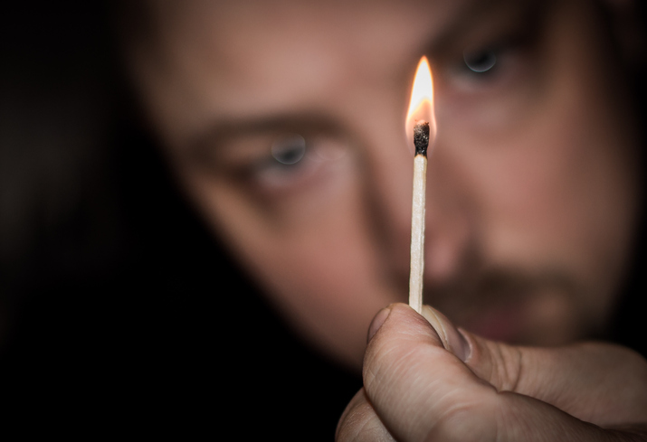 Close-Up Of Hand Holding Burning Matchstick