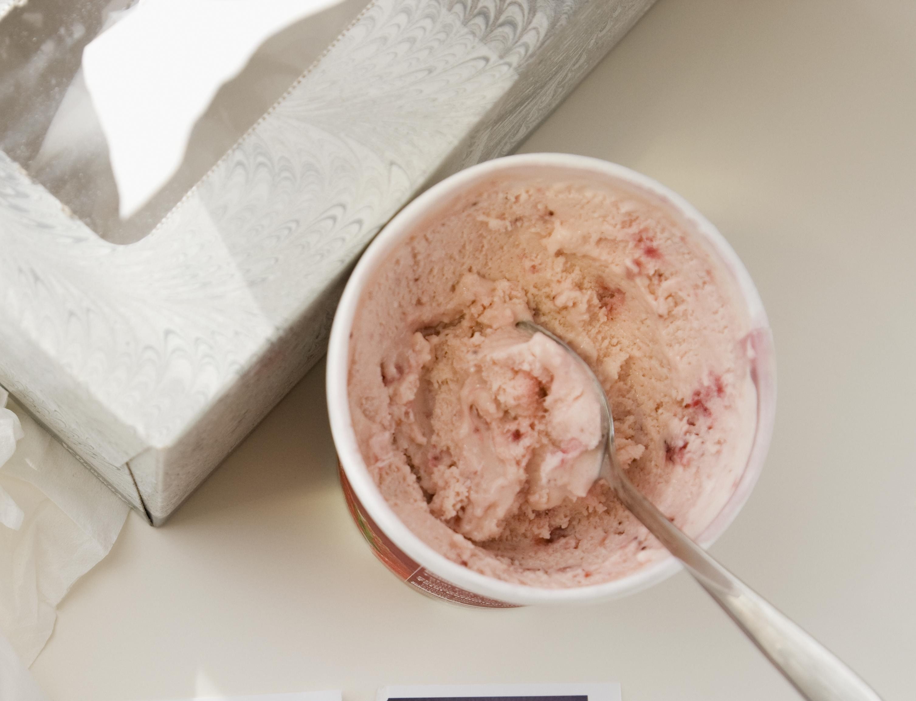 Ripped photograph next to ice cream and tissues
