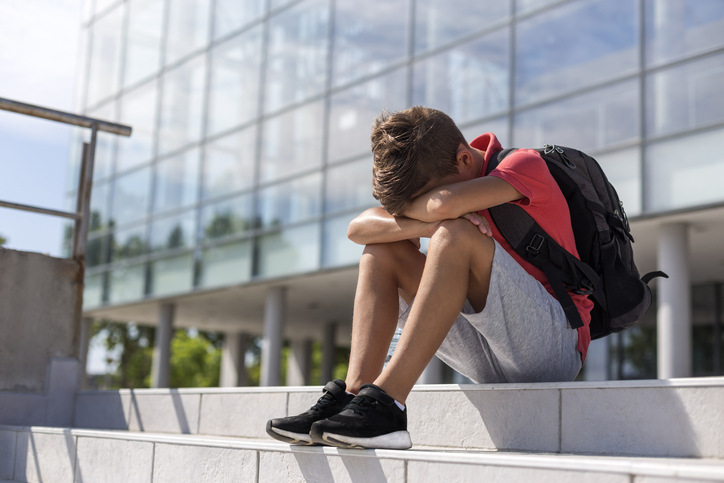 Sad boy sitting with head down