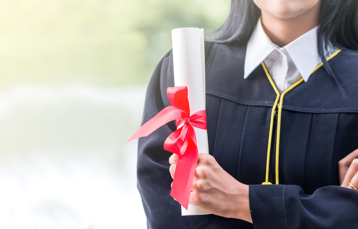 Midsection Of Woman In Graduation Gown Holding Certificate