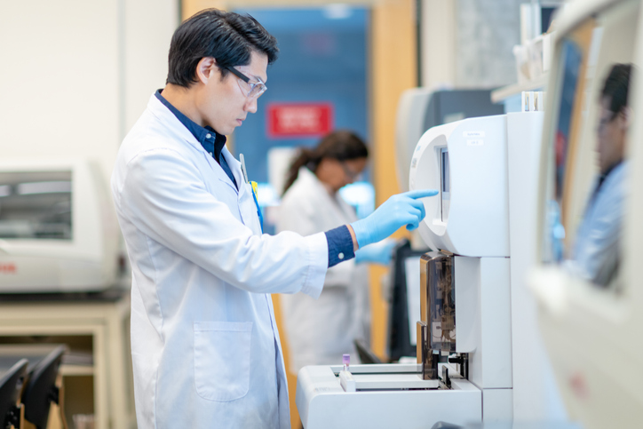 Asian Scientist Setting Medical Testing Equipment stock photo