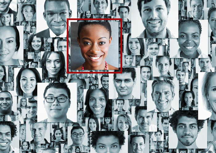 Many portraits of diverse people, one standing out from the crowd