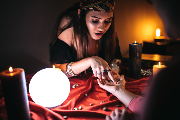 Fortune teller reading from palm