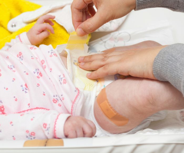 Cropped Hands Changing Diaper Of Baby
