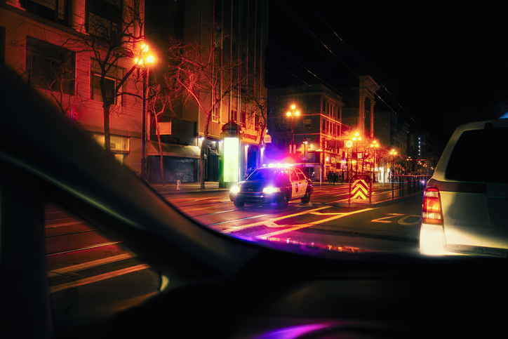 Police car with emergency lights on in downtown district