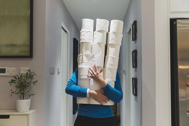 Person holding large piles of toilet rolls