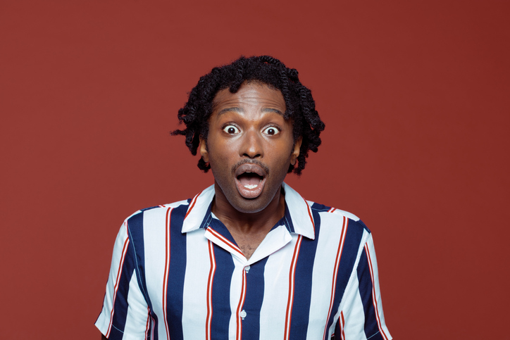 Shocked young man in retro style striped short sleeved shirt