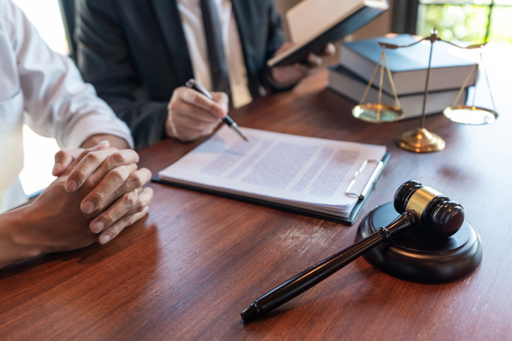 Midsection Of Lawyer Explaining Document To Woman In Office