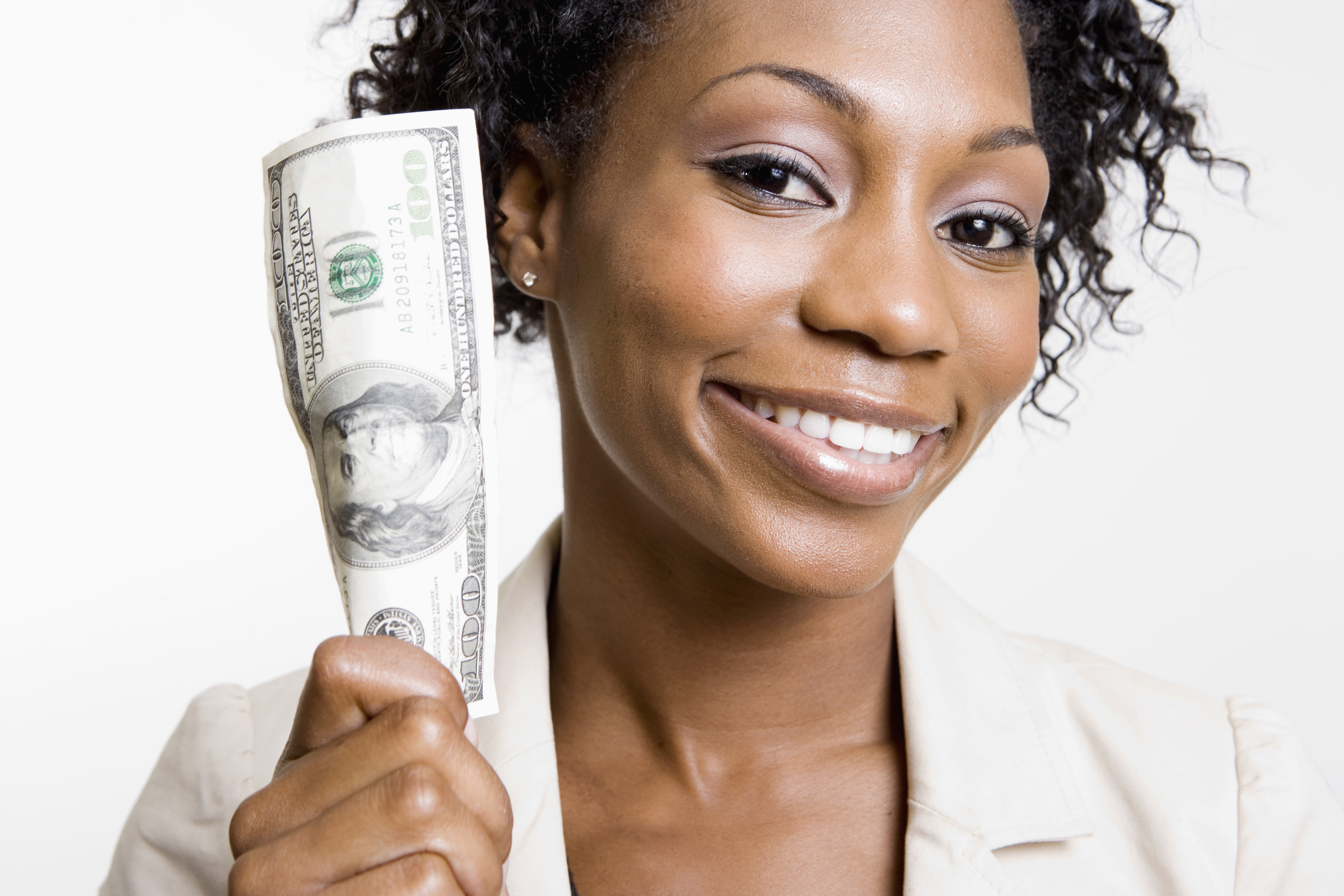 African American woman holding hundred dollar bill - stock photo