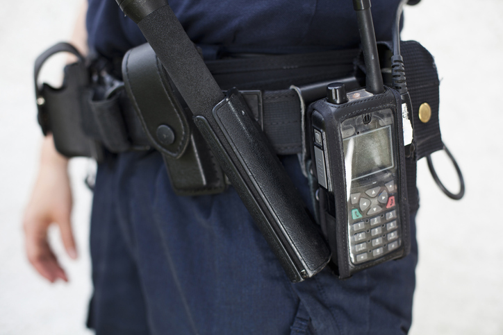 Midsection of a police officer with walkie-talkie and night stick on equipment belt