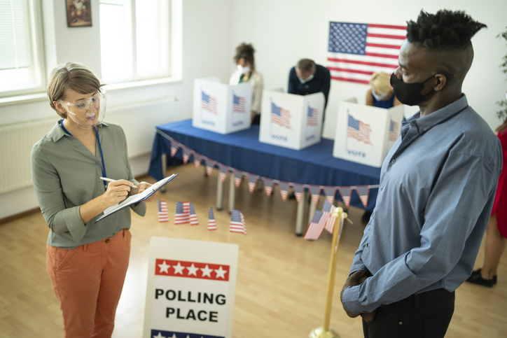Female volunteer asking exit poll questions at election voting center