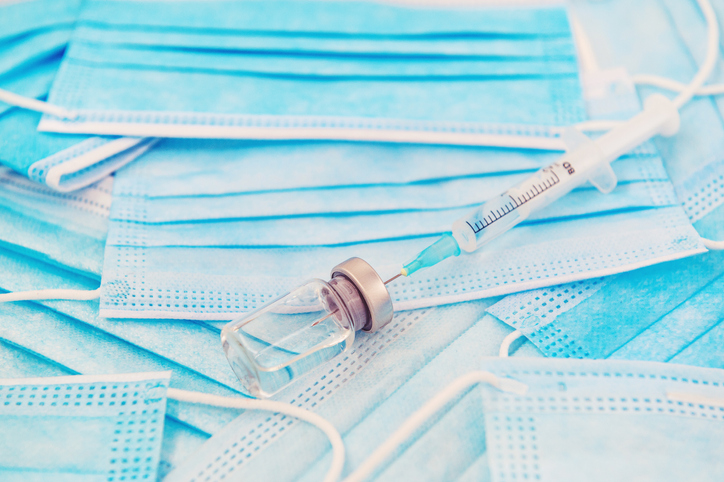 Vaccine over a stack of face protection masks