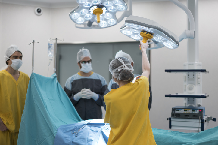 Young female nurse adjusting lighting at operating room