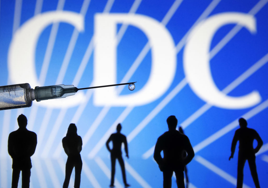 In this photo illustration a medical syringe and small...