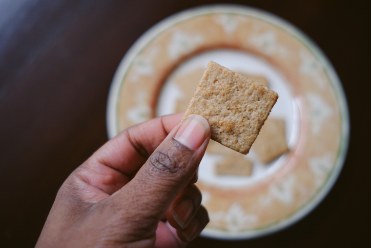 Woman Snacks on Whole Grain Crackers