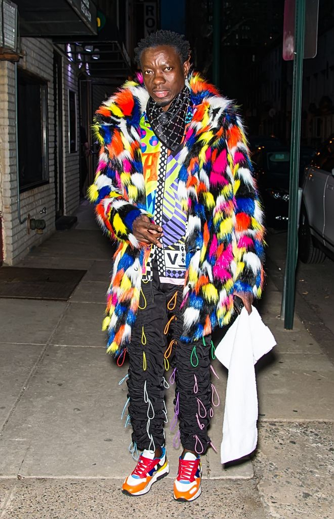 Michael Blackson in hair tie pants and colorful shirt