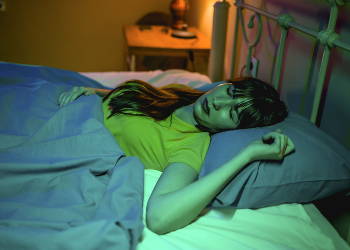 Woman sleeping in bed at home