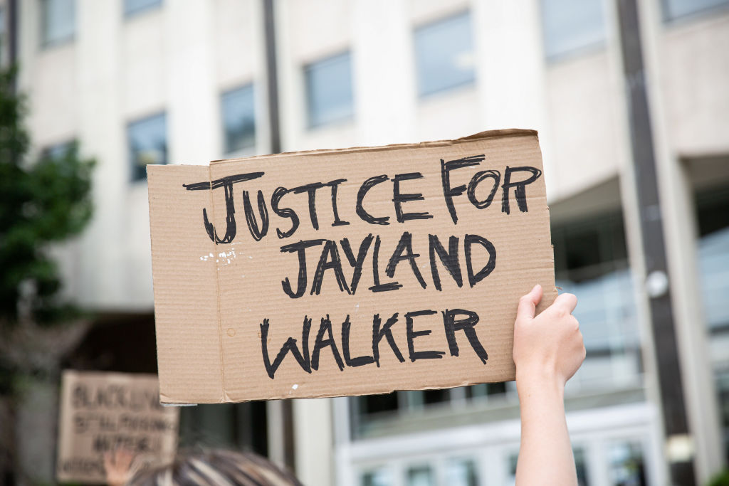 A protester holds a sign that says, "Justice for Jayland...