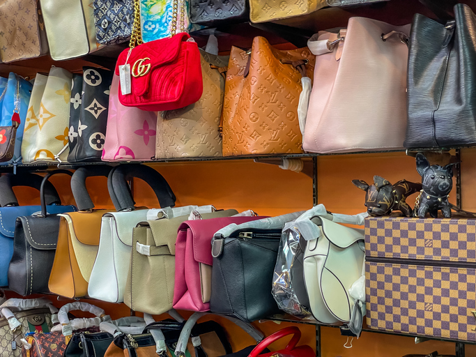 Rows of Counterfeit Fake Poor quality Handbags such as Chanel & Louis Vuitton being sold at backstreet markets to unknowing tourists. Good copies that fool the buyer but often fall apart very quickly due to cheap and inexpensive quality