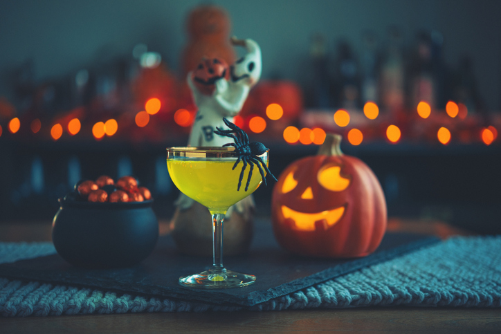 Halloween time. Vibrant colored drinks with cauldron of candy