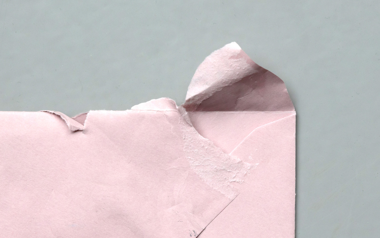 Torn envelope on a grey background