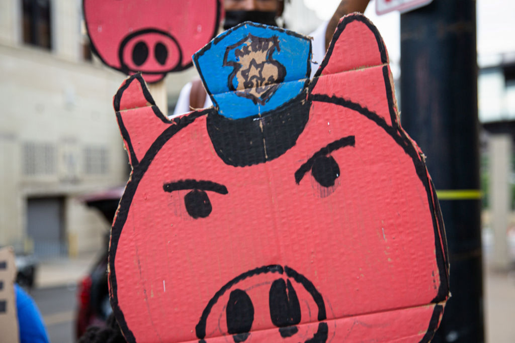 A pig sign with a police hat is seen during the...