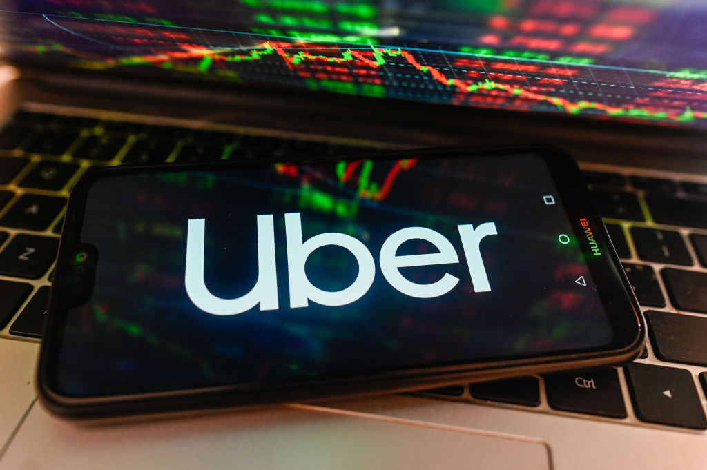 In this photo illustration, Uber logo is displayed on a...