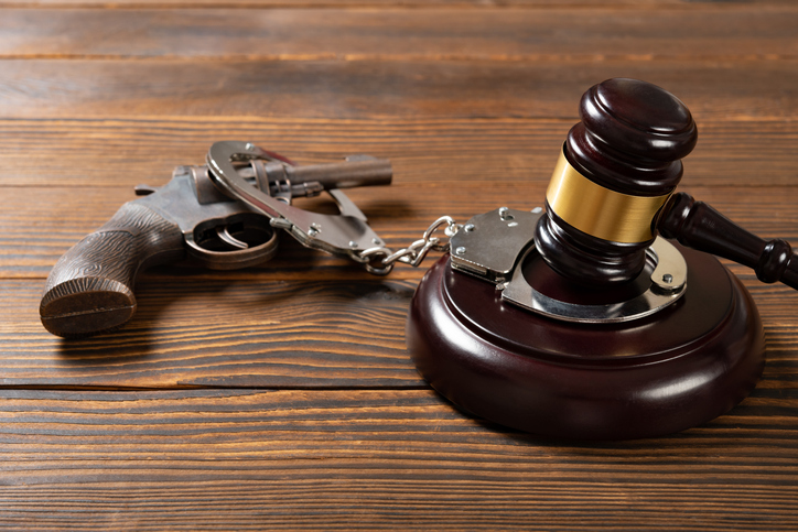 angle view gavel and gun and handcuffs