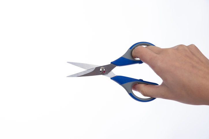 woman holding a pair of scissors on a white background, scissors on hand