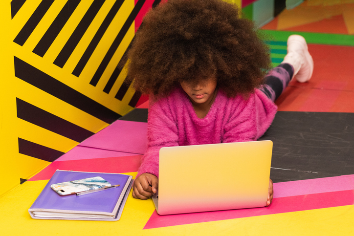 Black girl using laptop in studio