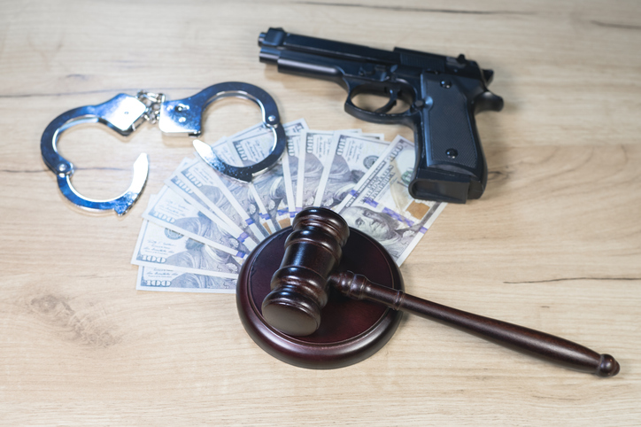 Judge Hammer for adjudication with handcuff, gun and dollars money. Auction or Lawyer decision. Law and justice concept. Court of law. Pronouncing sentence, striking Gavel.