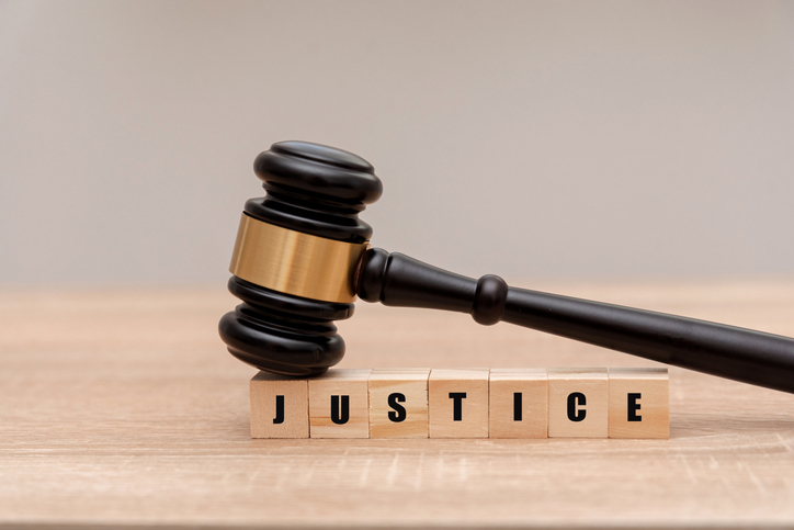 Judge gavel on A wooden block with the word justice written on it, legal authority and fairness