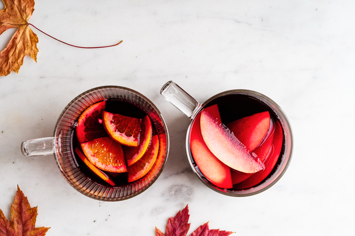 Hhibiscus tea, warming fall drink with apple and citrus slices in glass mugs
